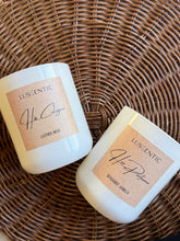 Load image into Gallery viewer, Two Luscentic candles on a wicker surface