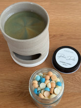 Load image into Gallery viewer, Ceramic mug with green liquid, jar of colorful candies, and container labeled 'Rum Dule' on a wooden surface.