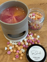 Load image into Gallery viewer, Wax melter with wax melts and a container of colorful candies on a wooden surface
