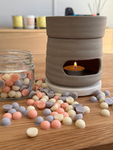 Load image into Gallery viewer, Ceramic oil burner with a lit candle on a wooden surface with colorful wax melts.
